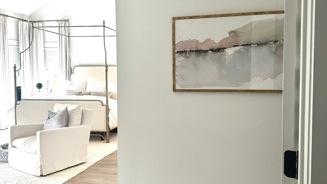 Modern interior with a neutral color palette, featuring a sofa, coffee table, and abstract art on the wall.